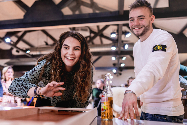 Deelnemers werken samen aan een interactieve opdracht met een digitaal scherm tijdens een groepsactiviteit