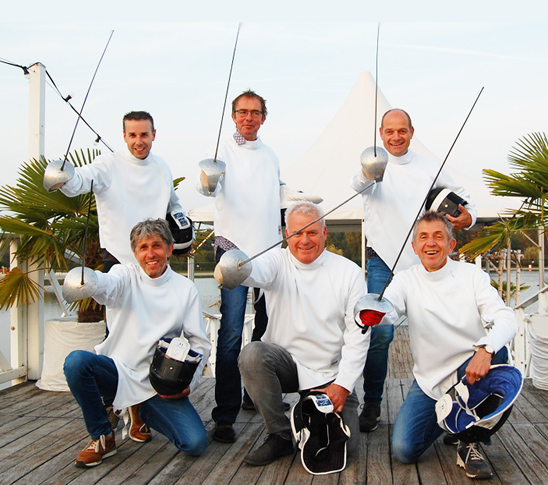 De zes deelnemers van een workshop schermen maken een groepsfoto op het gras bij Fun Beach Panheel, het leukste bedrijfsuitje of personeelsuitje van Limburg.