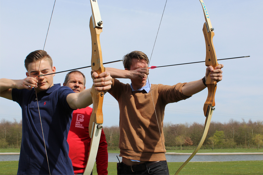Twee mensen die gaan handboogschieten terwijl de instructeur uitlegt hoe het moet. Leuke activiteit voor een personeelsuitje of bedrijfsuitje in Midden-Limburg.