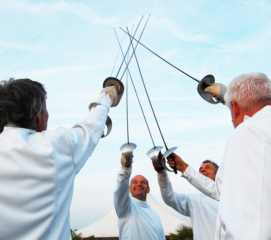 Mannen die de degen in de lucht steken en een workshop schermen krijgen.