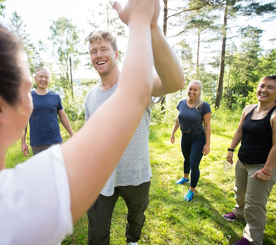 Mensen geven elkaar een high five na een geslaagde activiteit bij een middag van Fun Beach Group Events. Ideaal voor een personeelsuitje, bedrijfsuitje, teambuilding of schoolreisje.