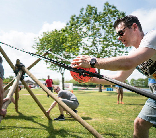 Iemand schiet een bal met een katapult bij Fun Beach in Panheel. De leukste locatie voor een bedrijfsuitje, personeelsuitje, familiedag, sportdag of schoolreisje in Limburg.