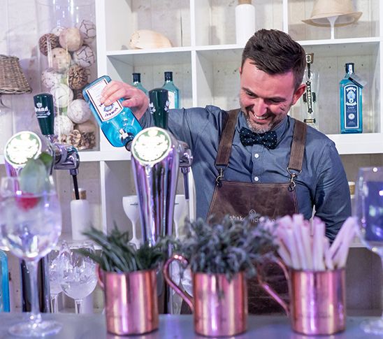 Bartender die uitlegt hoe je cocktails moet bereiden tijdens een cocktailworkshop.