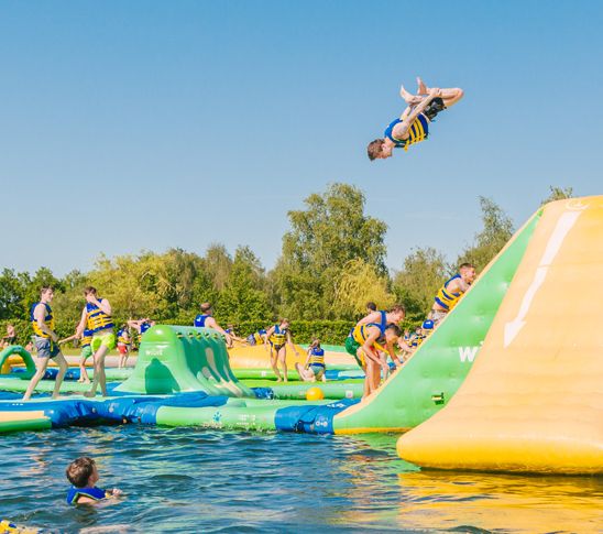 Een jongen springt van het aquapark af tijdens een schoolreisje bij Fun Beach Group Events.